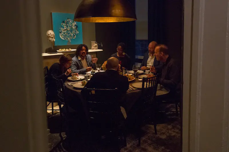 People talking gathered around a dining table